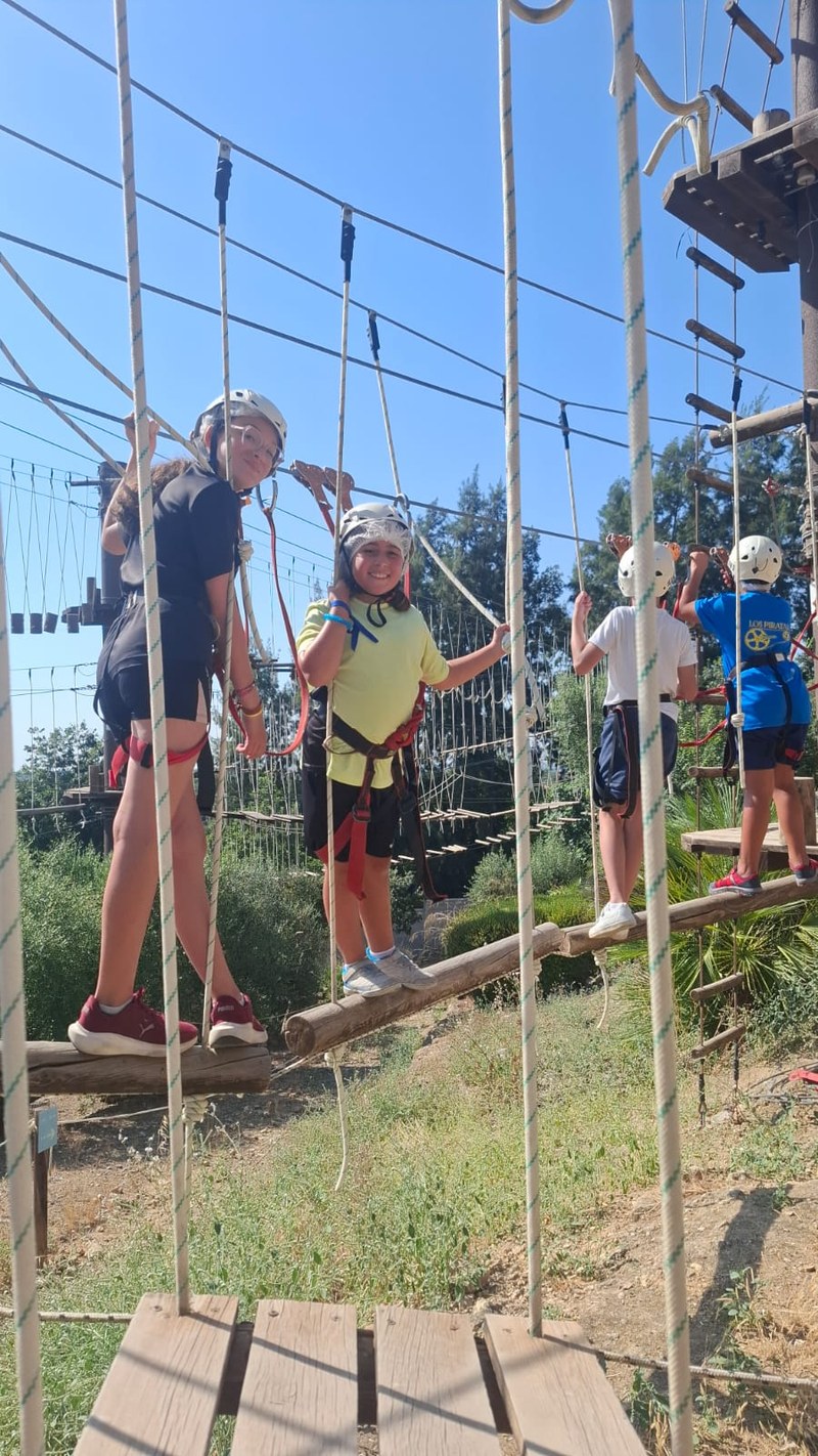 4 participantes haciendo una actividad multiaventura en un puente colgante.