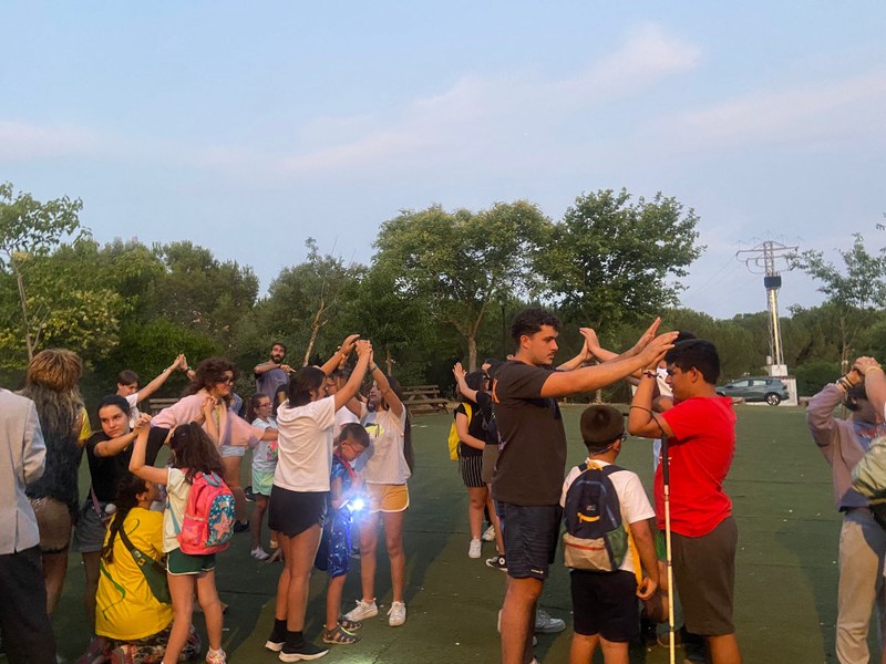 Participantes y monitores realizar juegos al atardecer.