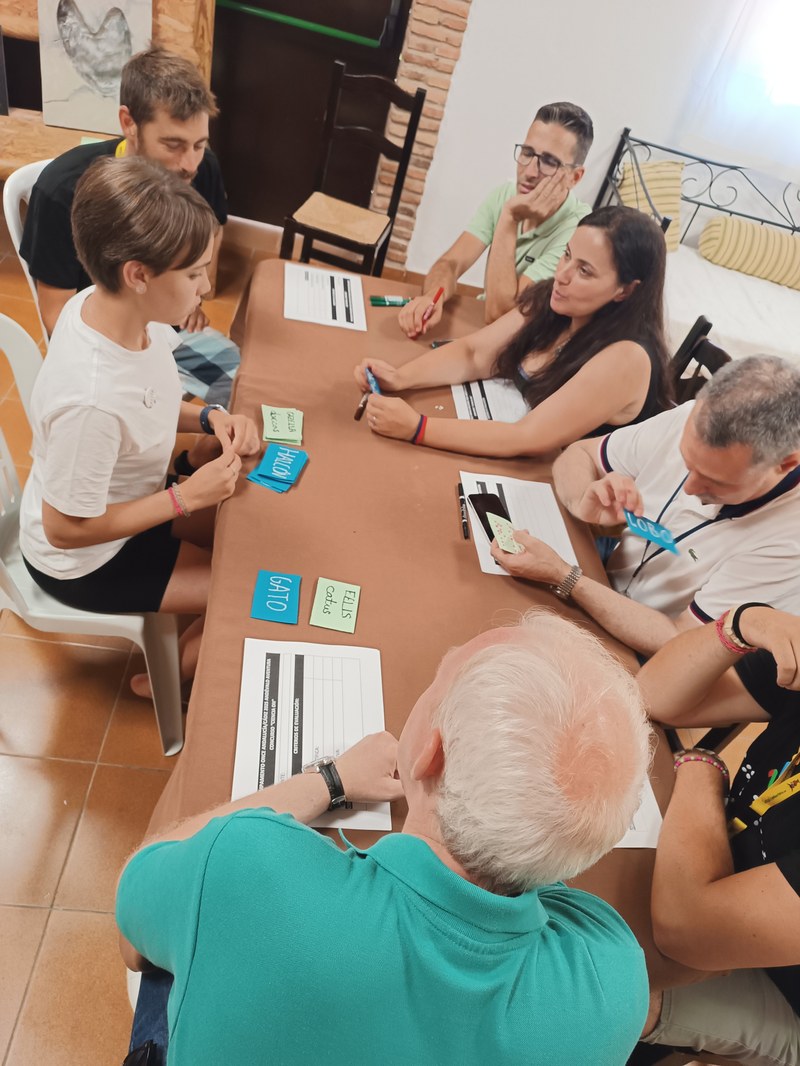 Una participante muestra un juego de cartas con nombres de animales al jurado.