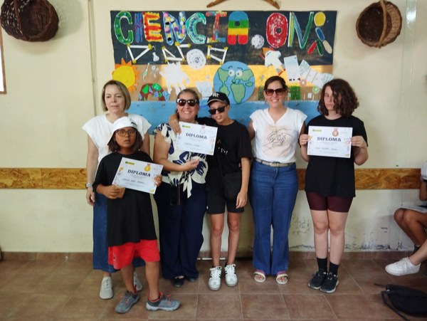 Un grupo de participantes posan con sus diplomas de participación.