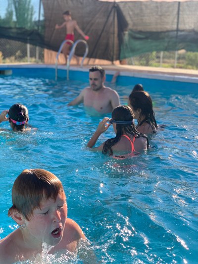 Grupo de participantes se refresca en la piscina