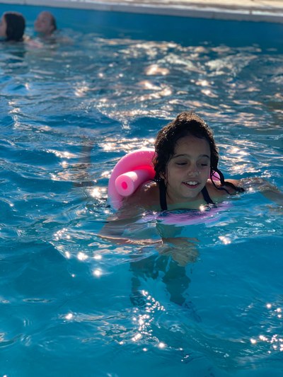 Una de las participantes nada en la piscina con un flotador