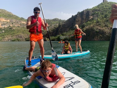 Dos participantes hacen paddle surf acompañados por dos responsables. Dos participantes hacen paddle surf acompañados por dos responsables.