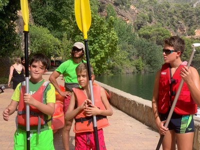 Tres niños con chaleco salvavidas y remo. Tres niños con chaleco salvavidas y remo.