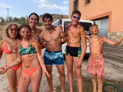 Participantes y monitora, cubiertos de barro, posan ante la cámara Participantes y monitora, cubiertos de barro, posan ante la cámara