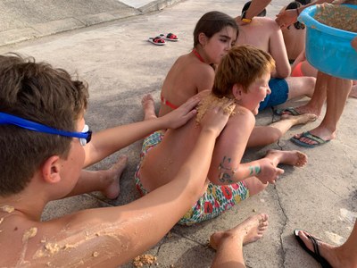 Un participante echa barro por la espalda a otro Un participante echa barro por la espalda a otro