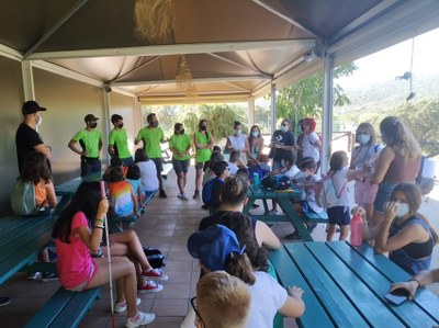 Los niños, sentados en mesas con bancos, atienden a las explicaciones de los monitores Los niños, sentados en mesas con bancos, atienden a las explicaciones de los monitores