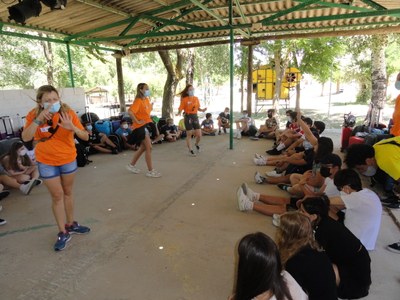 Equipo de monitores realiza una presentación con los niños sentados en el suelo-1