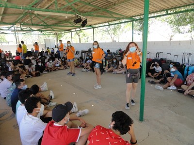 Equipo de monitores realiza una presentación con los niños sentados en el suelo-2