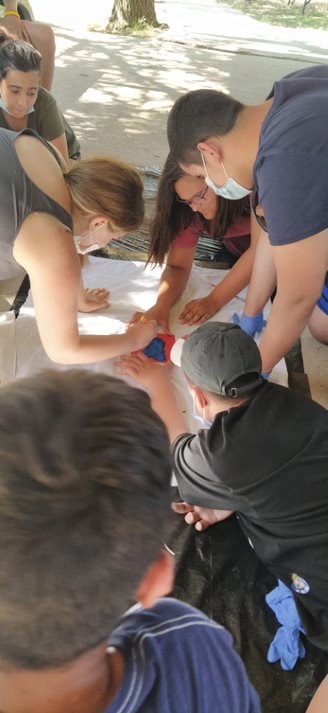 Grupo pintando un detalle en el taller de pintura de telas