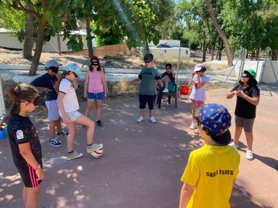 Niños en corro con los ojos vendados practicando pases entre ellos