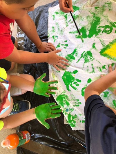 Niños pintando con las manos en el taller de pintura de telas