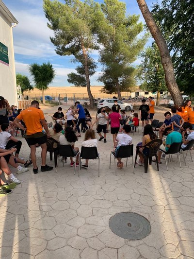 Niños sentados en un círculo de sillas realizan un juego Niños sentados en un círculo de sillas realizan un juego