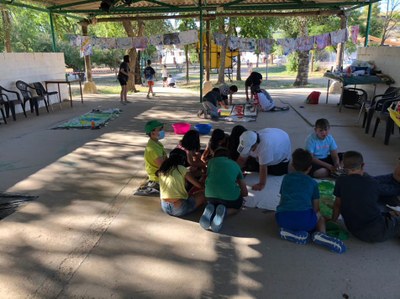 Vista general del taller de pintura de telas, con niños pintando telas en en suelo