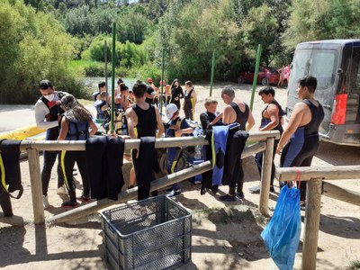 Chicos y chicas poniéndose los trajes de neopreno para hacer rafting Chicos y chicas poniéndose los trajes de neopreno para hacer rafting