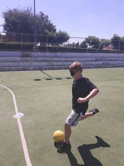 Niño con los ojos vendados chutando el balón