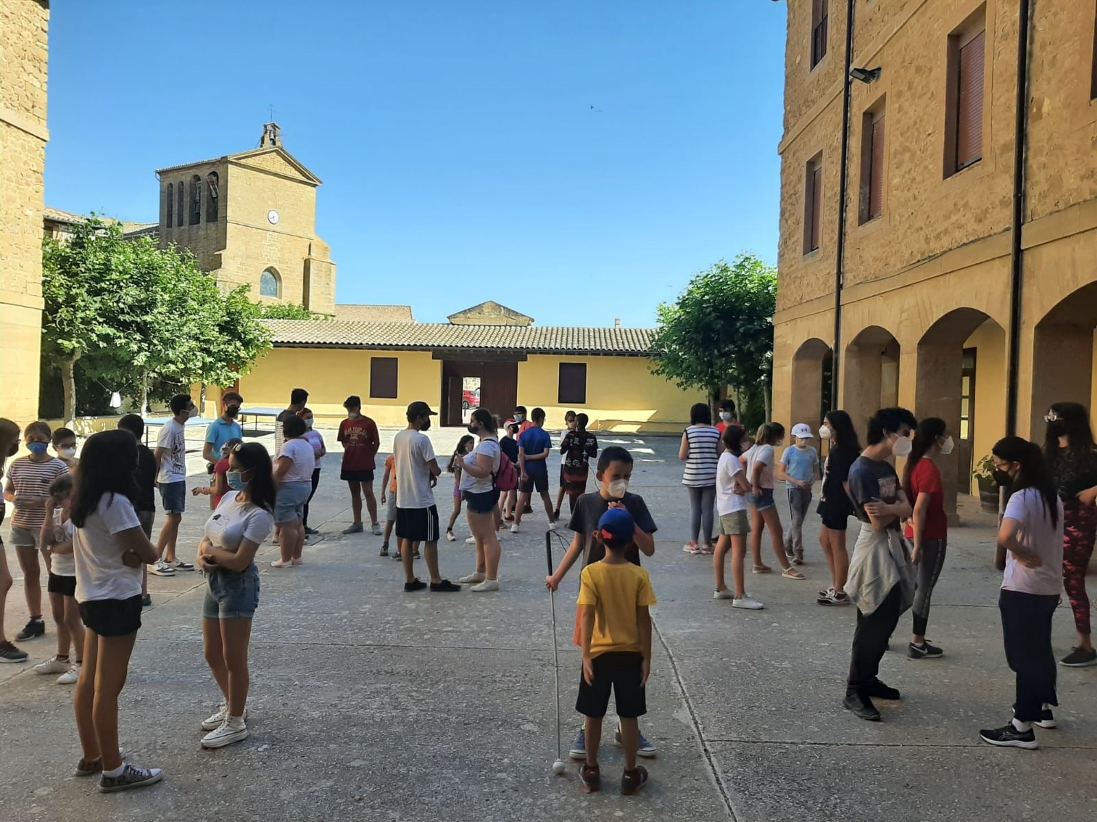 El grupo de participantes realiza juegos de presentación en la plaza del pueblo