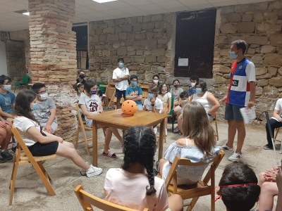 El grupo de participantes, sentado en círculo, escucha las instrucciones del monitor El grupo de participantes, sentado en círculo, escucha las instrucciones del monitor