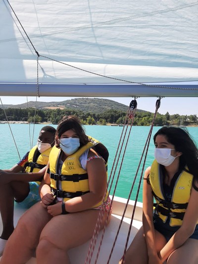 Tres participantes disfrutan en el barco de vela Tres participantes disfrutan en el barco de vela
