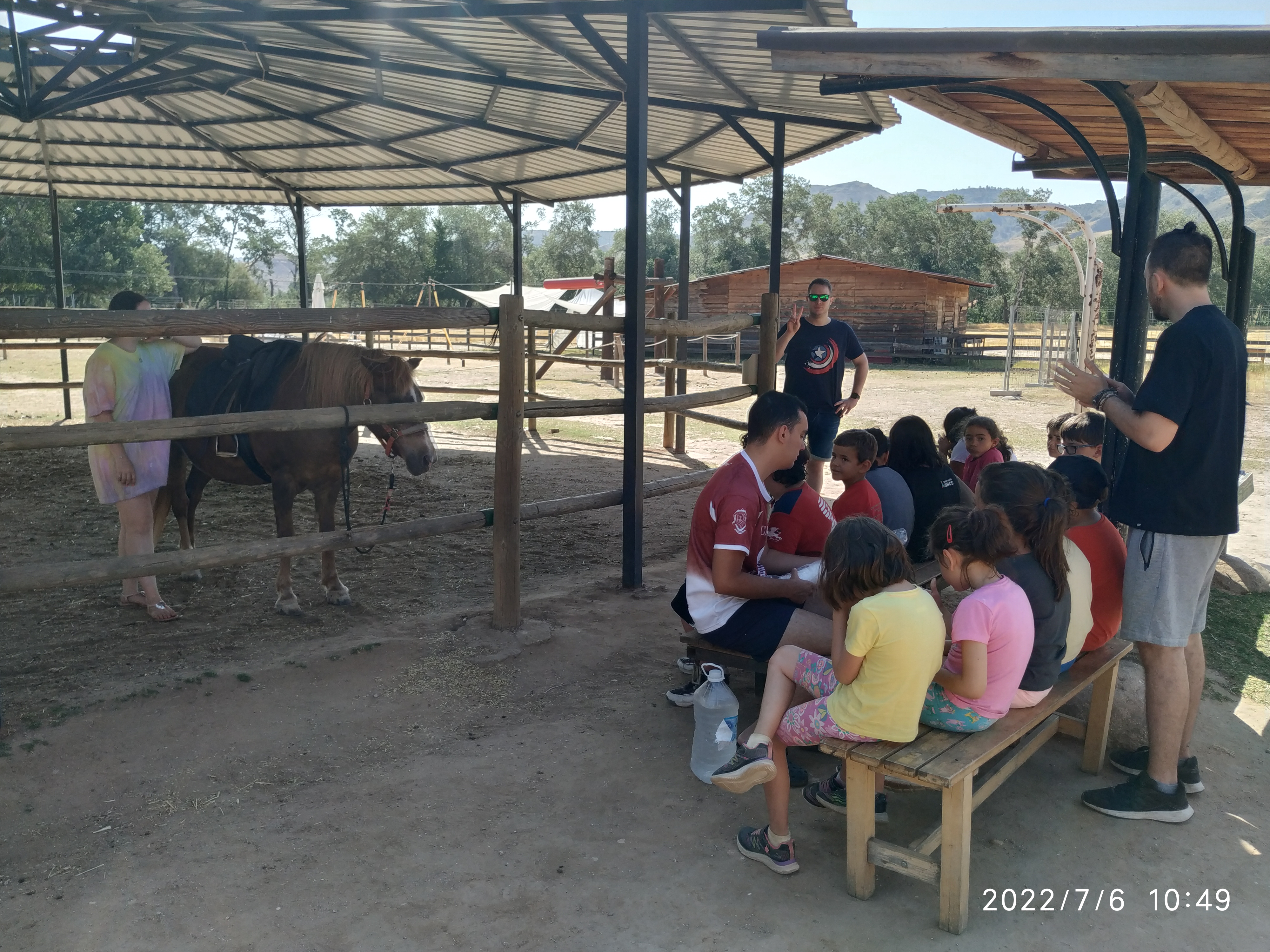 Los participantes en la zona de equitación de la granja, sentados frente a un poni