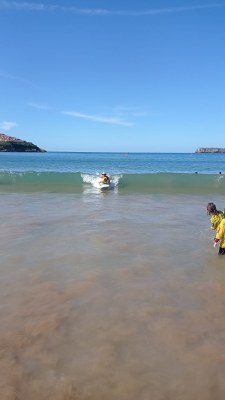 Un participante surfea una ola con un monitor