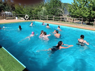 Varios participantes se quitan el calor bañándose en la piscina