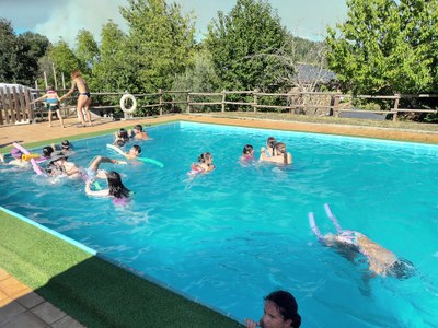 Un grupo de participantes nada en la piscina