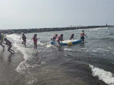 Monitores y participantes metiendo un kayak en el agua