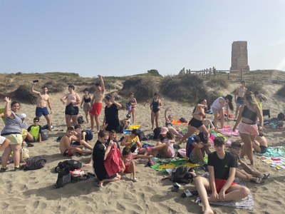 Todos los participantes sentados en la playa