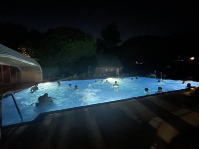 Participantes y monitores dándose un baño nocturno en la piscina