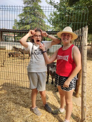 Dos participantes en la granja, en la zona de las cabras