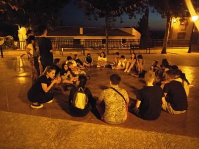 El grupo realiza un juego nocturno sentados en círculo
