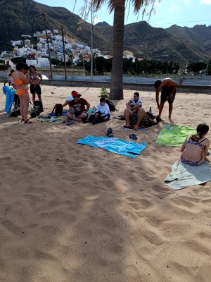 Un grupo de participantes en la playa, sentados sobre las toallas