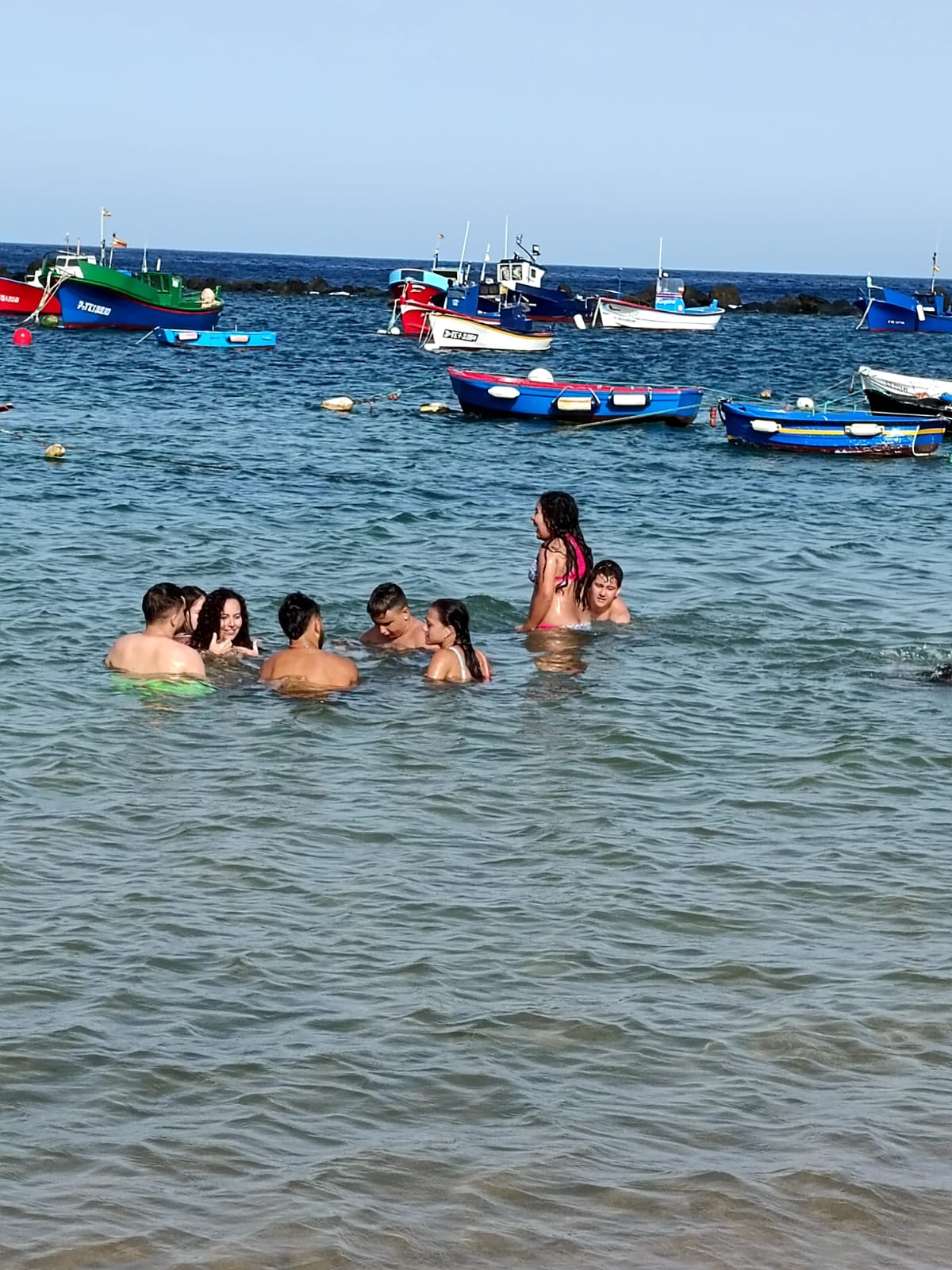 Varios participantes, bañándose en la playa