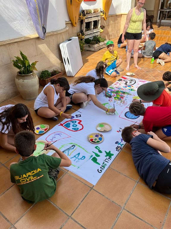 Un grupo de participantes pinta un mural en el taller de arte urbano