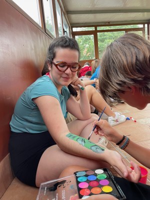 Participante pintando el brazo de otro participante en el taller de Body Painting