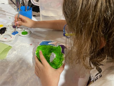 Participante pintando una máscara de escayola
