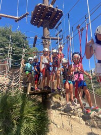 Un grupo de participantes pasando por un puente colgante