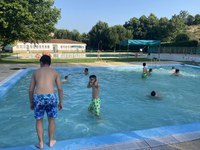 Varios participantes se bañan en la piscina.