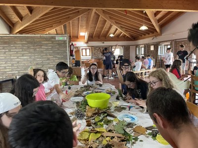 Varios participantes haciendo un paisaje con arcilla y elementos naturales