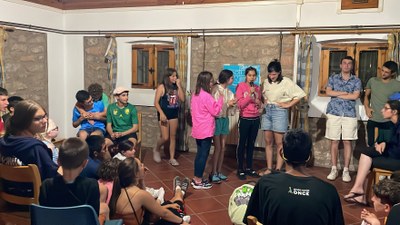 Un grupo de participantes agradeciendo los días en el campamento con un micrófono.  