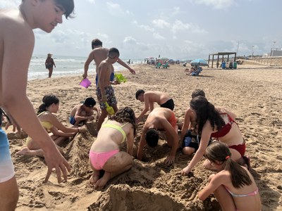 Los participantes juegan con la arena de la playa