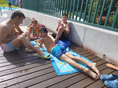 Grupo de participantes jugando a las cartas en el borde de la piscina