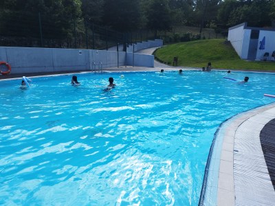 Vista de la piscina con un grupo de participantes jugando en el agua