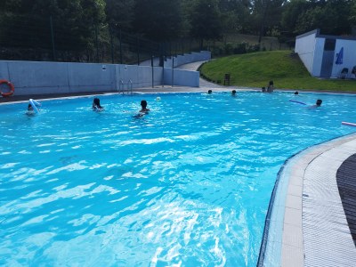 Vista de la piscina con un grupo de participantes jugando en el agua Vista de la piscina con un grupo de participantes jugando en el agua