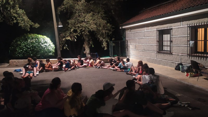 Velada nocturna con todo el grupo en círculo haciendo una actividad de masaje.