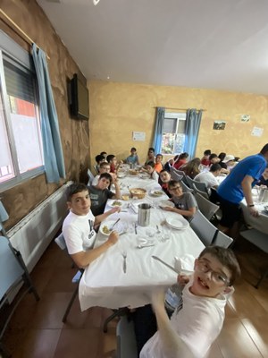 Varios participantes posan en el comedor sentados a la mesa.