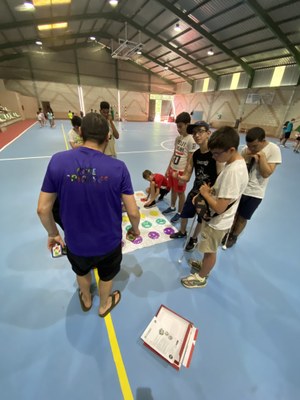 Un grupo de participantes hace un juego en el pabellón deportivo. 