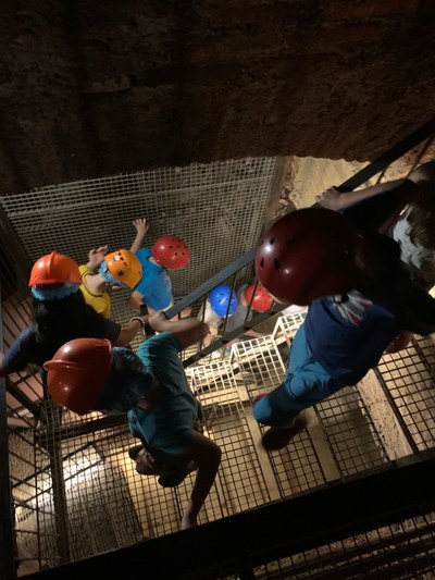 Participantes bajan unas escaleras durante la visita a la mina de Costanaza. 