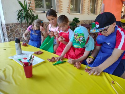 Varios participantes moldean y pintan sus figuras